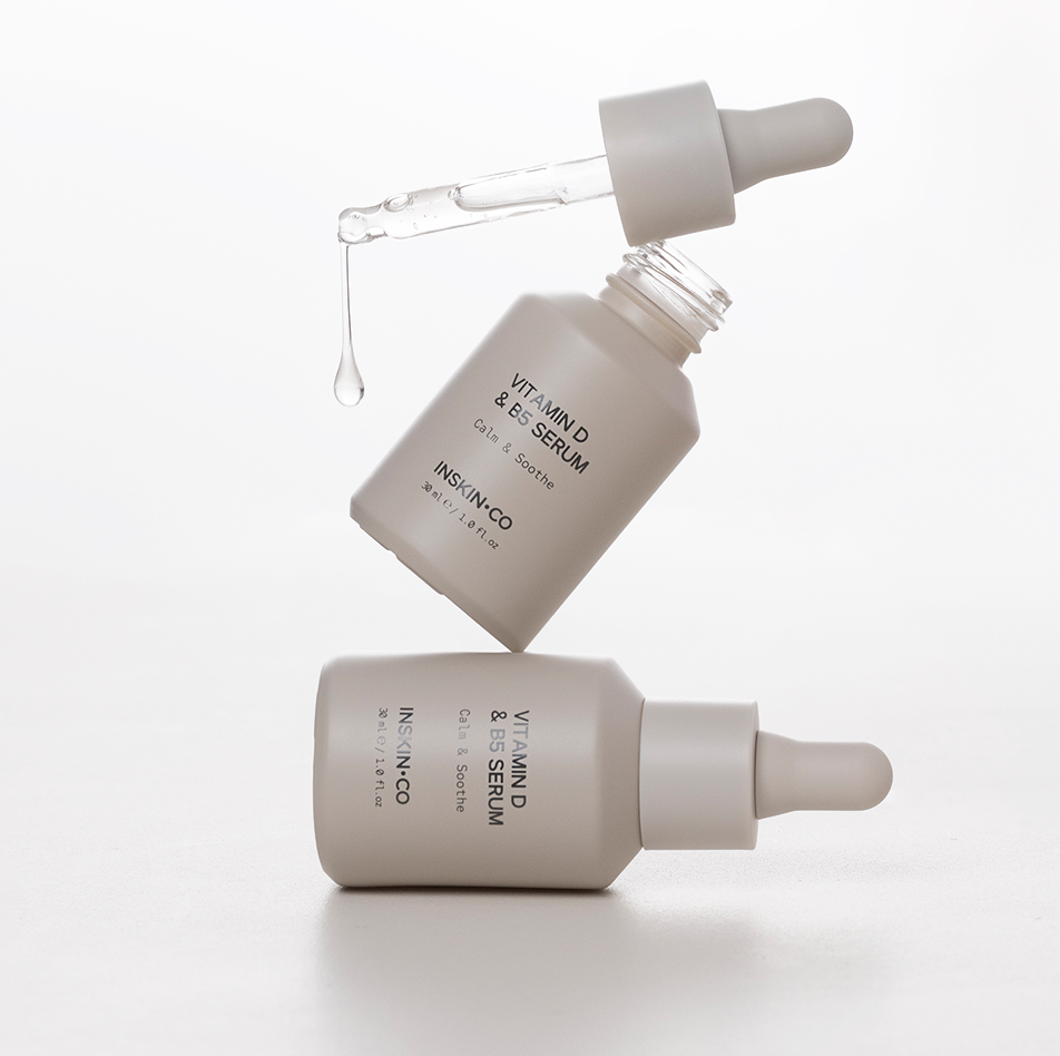INSKIN.CO Vitamin D & B5 Serum styled image with two bottles highlighting daily barrier repair and calming skincare routine.