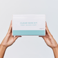 Aspect Clear Skin Kit box held by two hands, showcasing the complete clarifying skincare system for problematic and acne-prone skin.