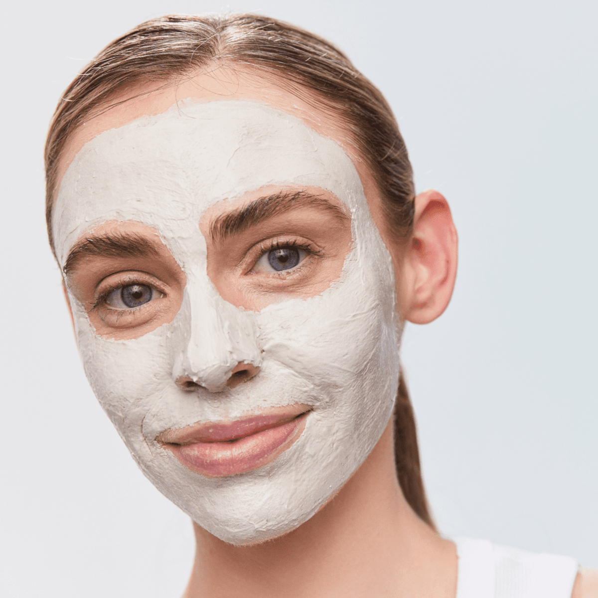 Woman with Aspect Exfoliating Clay Mask applied across her face, demonstrating the deep-cleansing clay and AHA/BHA exfoliating action for clearer, balanced skin.