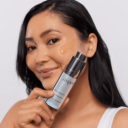 Woman applying Aspect Extreme B 17 serum to her face, demonstrating the niacinamide and vitamin B complex formula that hydrates, brightens and balances the skin.