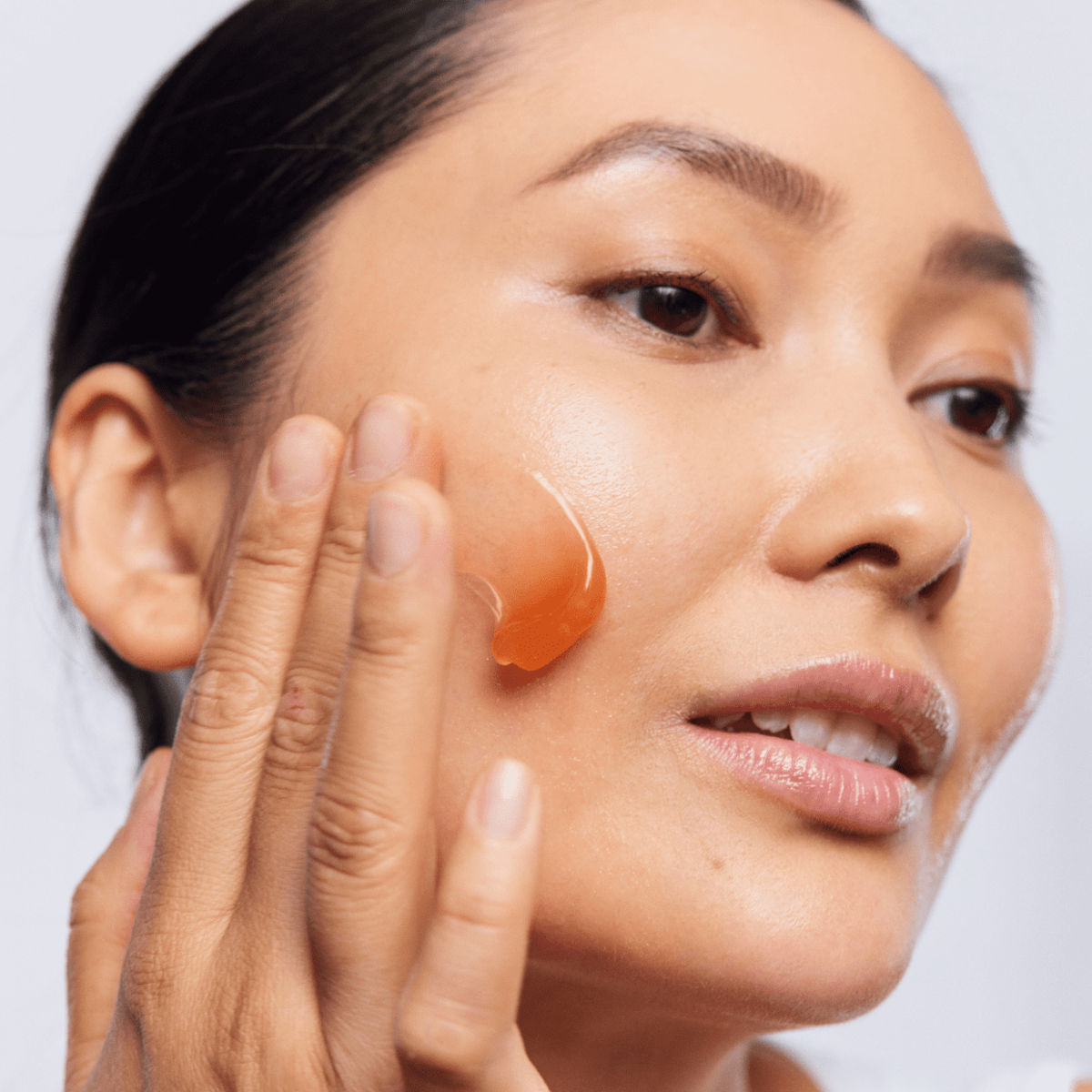 Woman applying Aspect Fruit Enzyme Mask to her face, demonstrating the enzyme-rich gel that exfoliates, hydrates and refines skin texture.