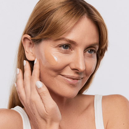 Woman applying Aspect Pigment Punch+ serum to her face, demonstrating the lightweight brightening formula designed to fade dark spots and even skin tone.