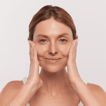 Woman lathering Aspect Purastat 5 Cleanser 100ml to show its silky foaming texture that exfoliates, brightens and deeply cleanses the skin.
