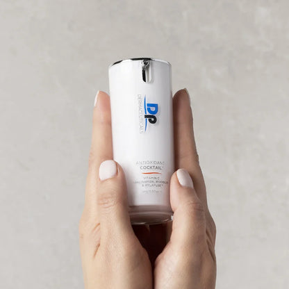Dp Dermaceuticals Antioxidant Cocktail 15ml held in hand, a lightweight antioxidant serum for brighter-looking skin and daily environmental defence.