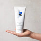 Hand holding Dp Dermaceuticals CLR Clarifying Mask against a grey background, showcasing product size and professional cosmeceutical packaging.