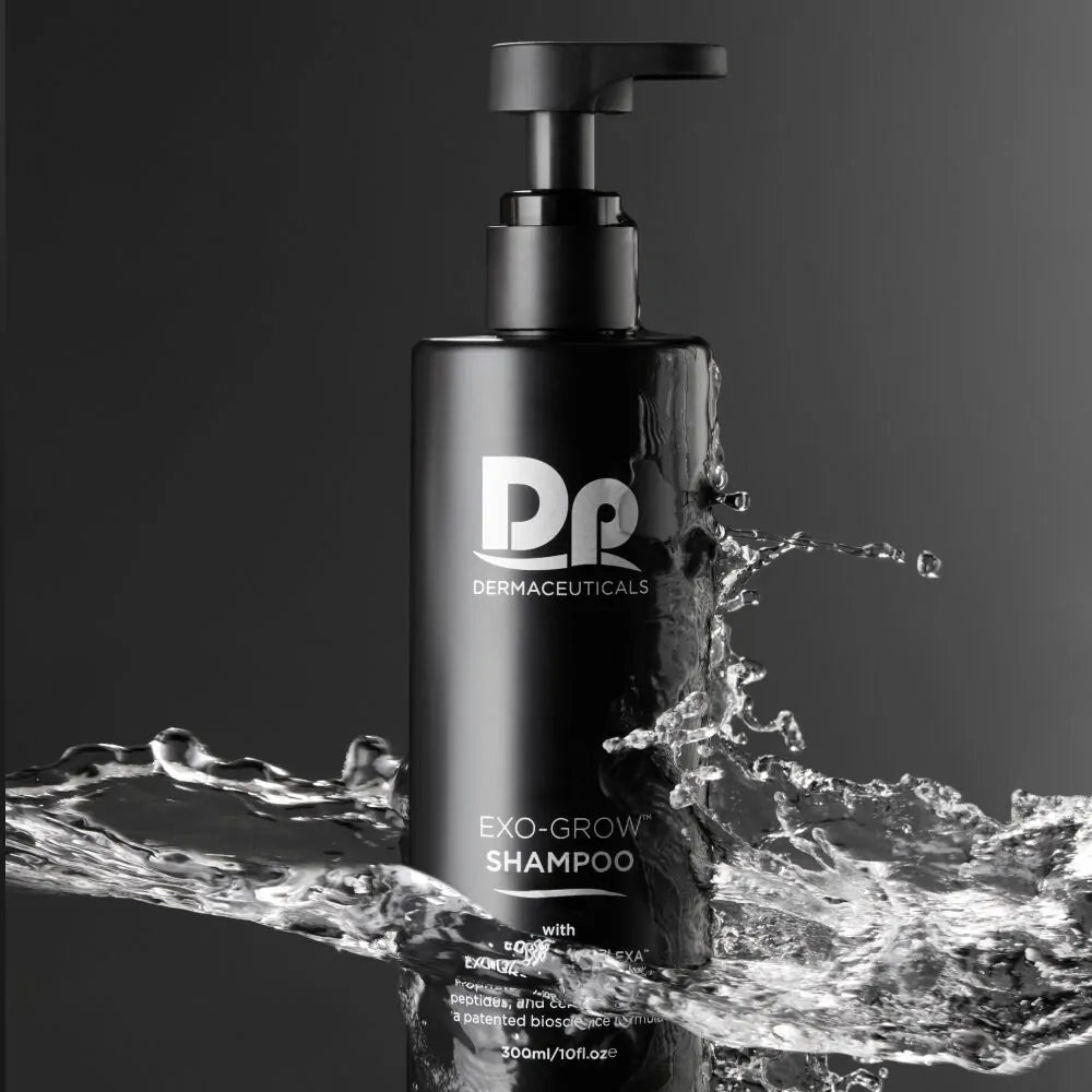 DP Dermaceuticals EXO-GROW Shampoo against a black background with water splashing over the bottle, highlighting hydration, scalp nourishment and anti-thinning benefits.
