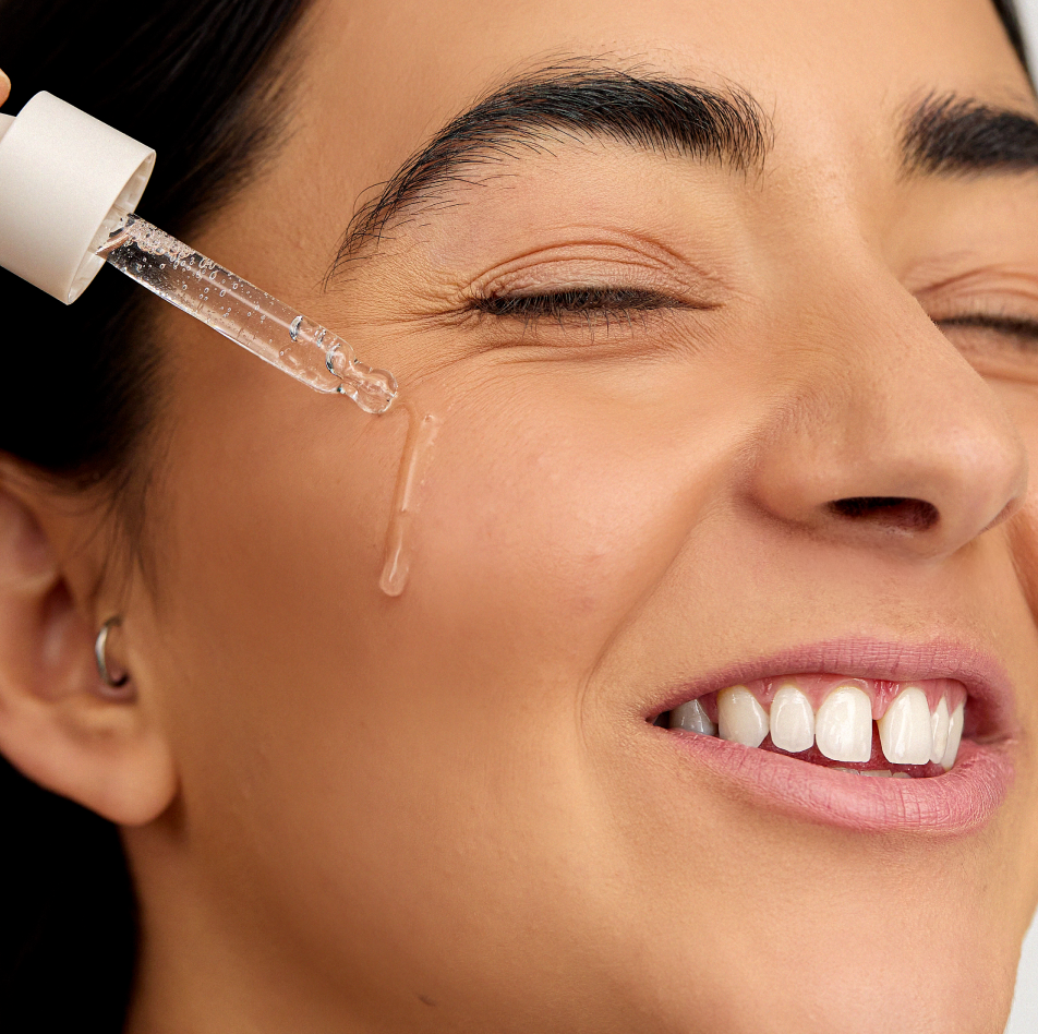 Woman applying INSKIN.CO Arbutin & B3 Serum to face showing lightweight arbutin and niacinamide serum for even skin tone.