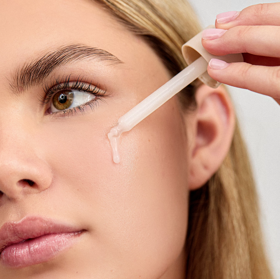 Woman applying INSKIN.CO Liquid Hydrator to face showing lightweight hydrating fluid for skin comfort and moisture balance.