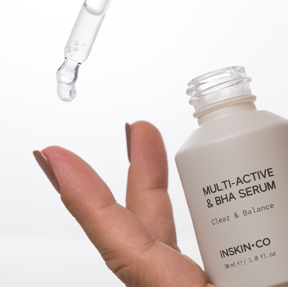 INSKIN.CO Multi-Active & BHA Serum dispensed onto fingers using dropper showcasing salicylic acid serum texture for congested skin.