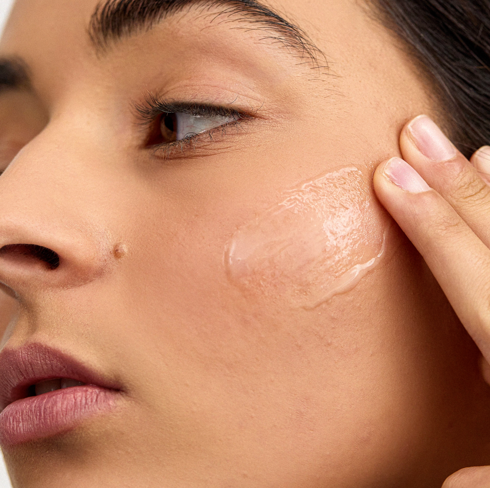 Woman applying INSKIN.CO Vitamin C Serum to face showing lightweight antioxidant serum for brighter, more even skin.