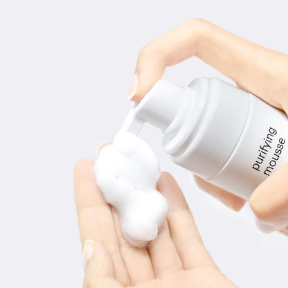 Mesoestetic Purifying Mousse being dispensed into hands, a lightweight foaming cleanser for oily and acne-prone skin to cleanse thoroughly without heavy residue.