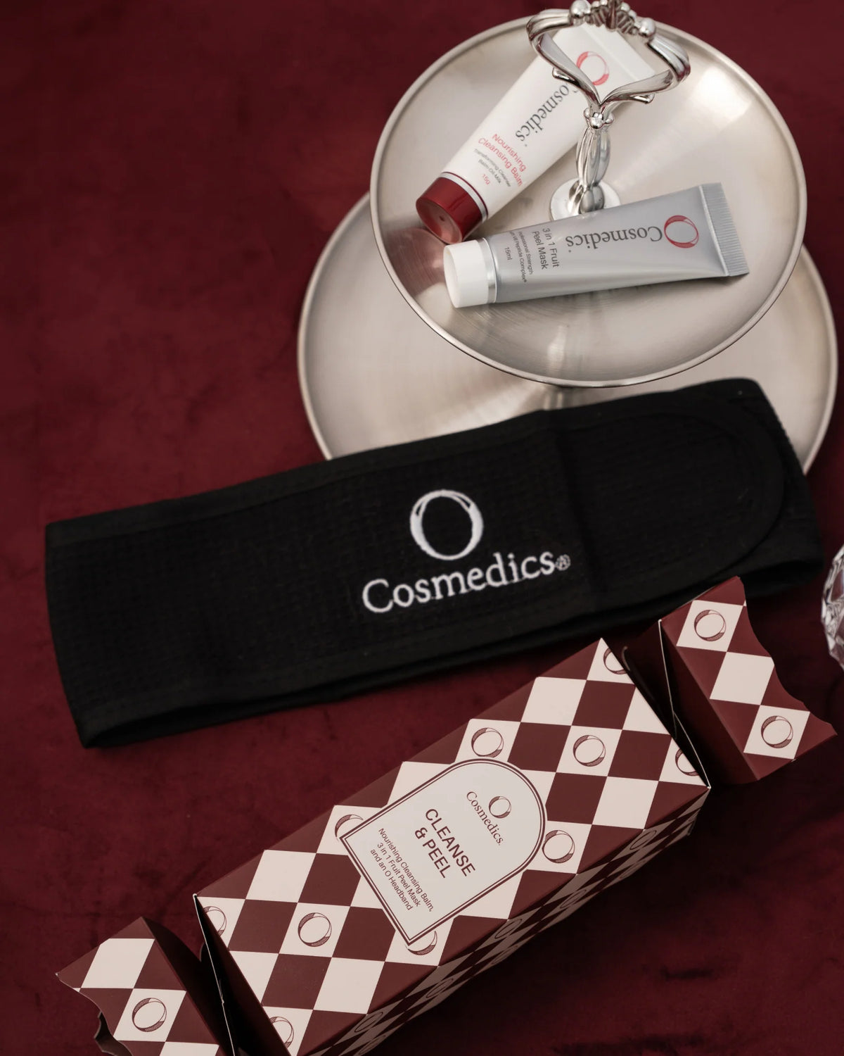 O Cosmedics Cleanse & Peel Bon-Bon festive skincare gift featuring hydrating O Cosmedics Nourishing Cleansing Balm, exfoliating O Cosmedics 3 In 1 Fruit Peel Mask and reusable O Cosmedics headband.