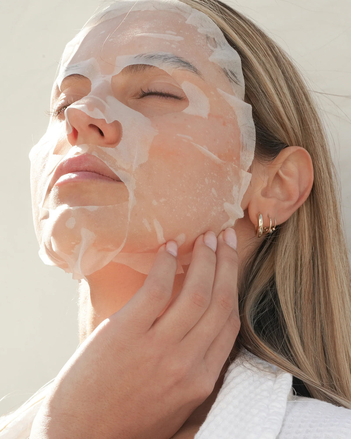 O Cosmedics V8 Peptide Sheet Mask applied to the face for concentrated hydration and smoother-looking skin.