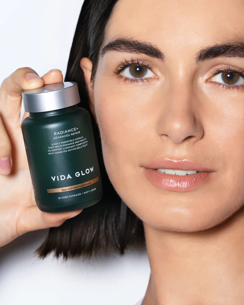 Vida Glow Advanced Repair Radiance+ brightening supplement shown with model for radiant skin and even tone support.